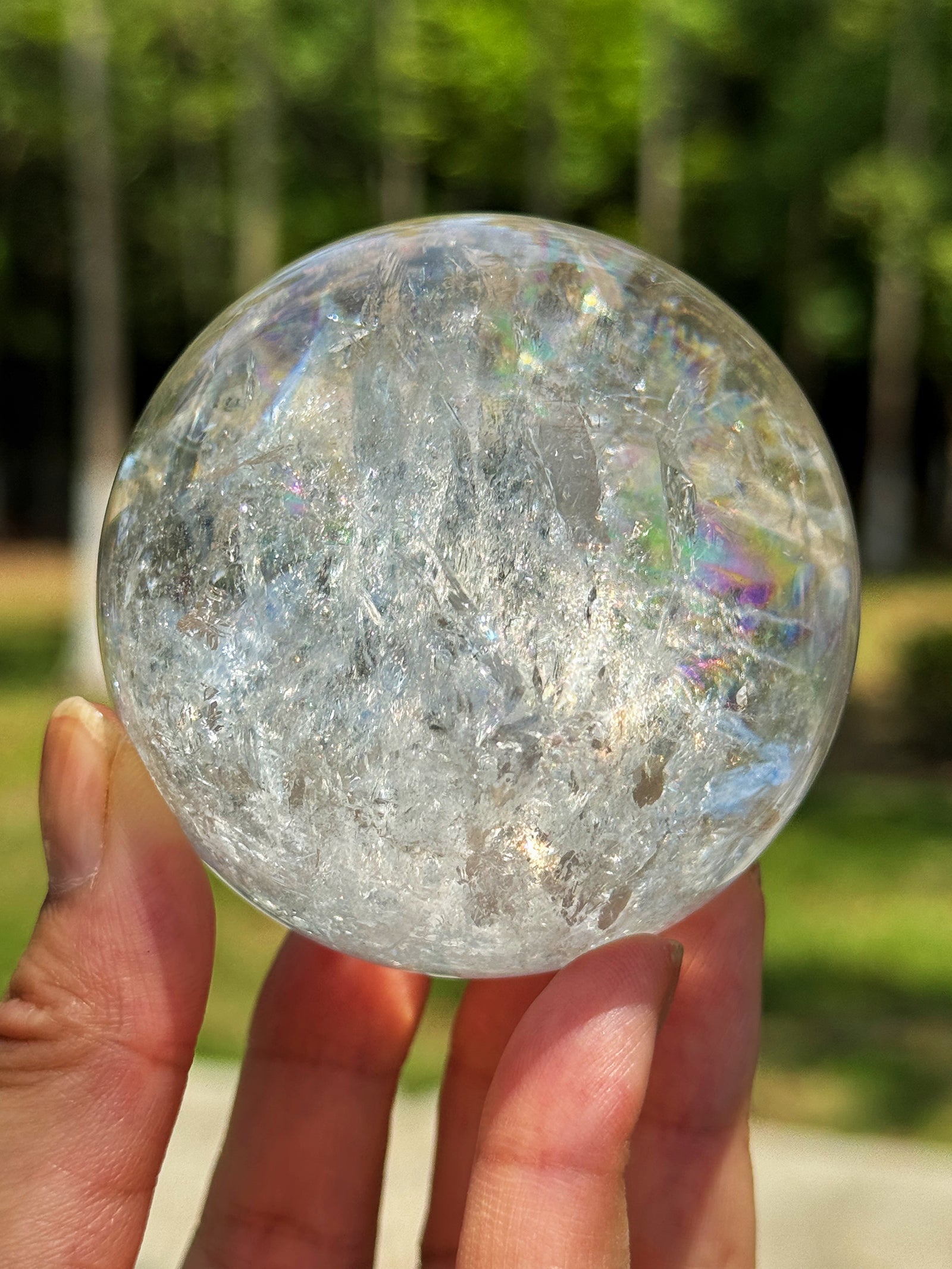 Natural rainbow reflections formed inside a clear quartz sphere under real sunlight
