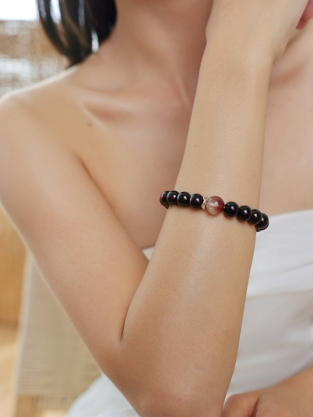 Model wearing a natural Garnet, Pink Rabbit Hair Quartz and Rose Quartz bracelet, featuring deep wine-red Garnet, delicate pink inclusions and soft pink Rose Quartz.