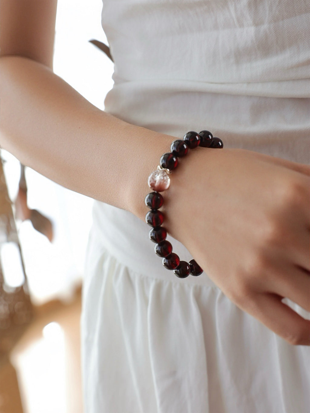 Model wearing a natural Garnet, Pink Rabbit Hair Quartz and Rose Quartz bracelet, featuring deep wine-red Garnet, delicate pink inclusions and soft pink Rose Quartz.