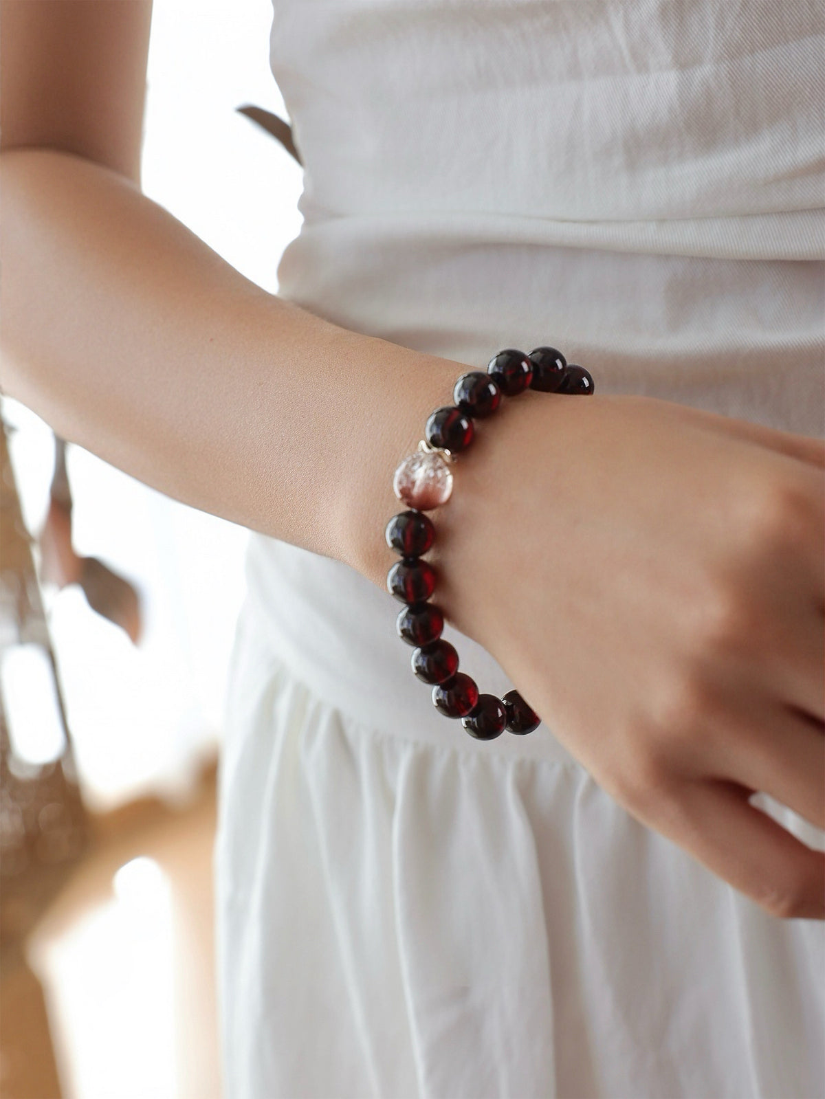 Model wearing a natural Garnet, Pink Rabbit Hair Quartz and Rose Quartz bracelet, featuring deep wine-red Garnet, delicate pink inclusions and soft pink Rose Quartz.