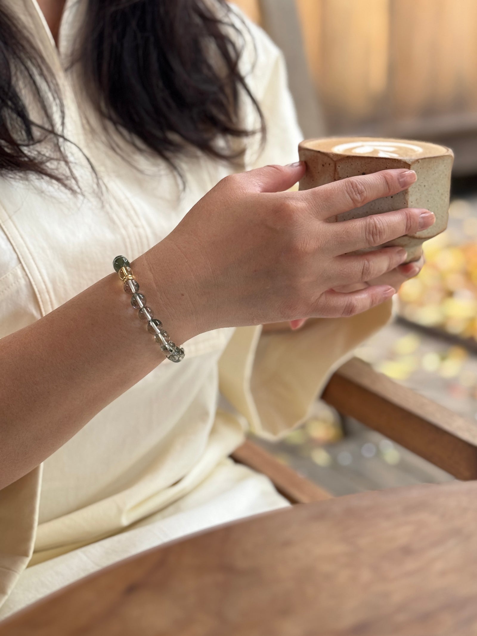 Green Phantom Quartz crystal bracelet worn in a relaxed lifestyle setting for abundance and confident energy
