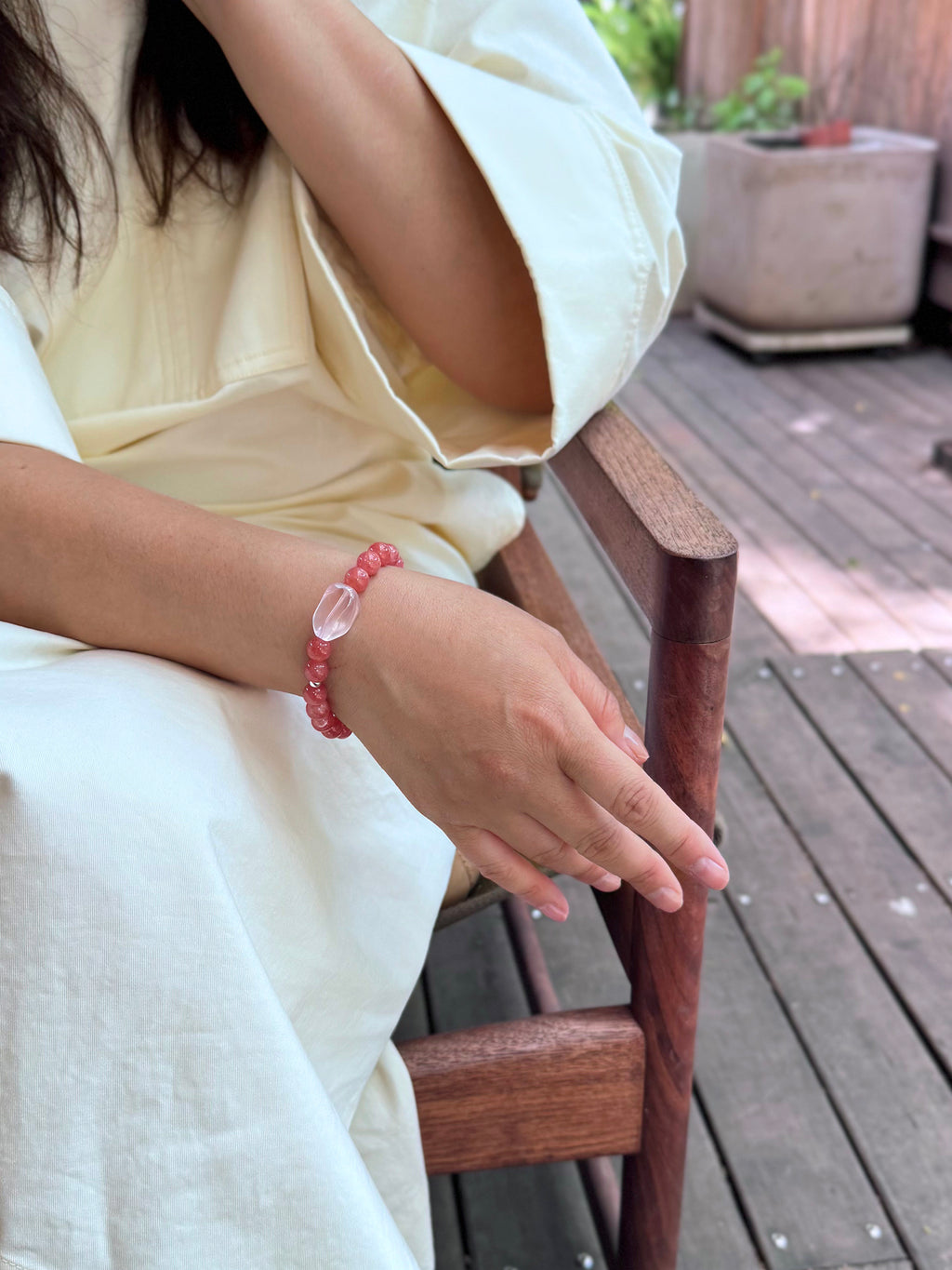 Rhodochrosite crystal bracelet worn in a relaxed lifestyle setting for love and emo
