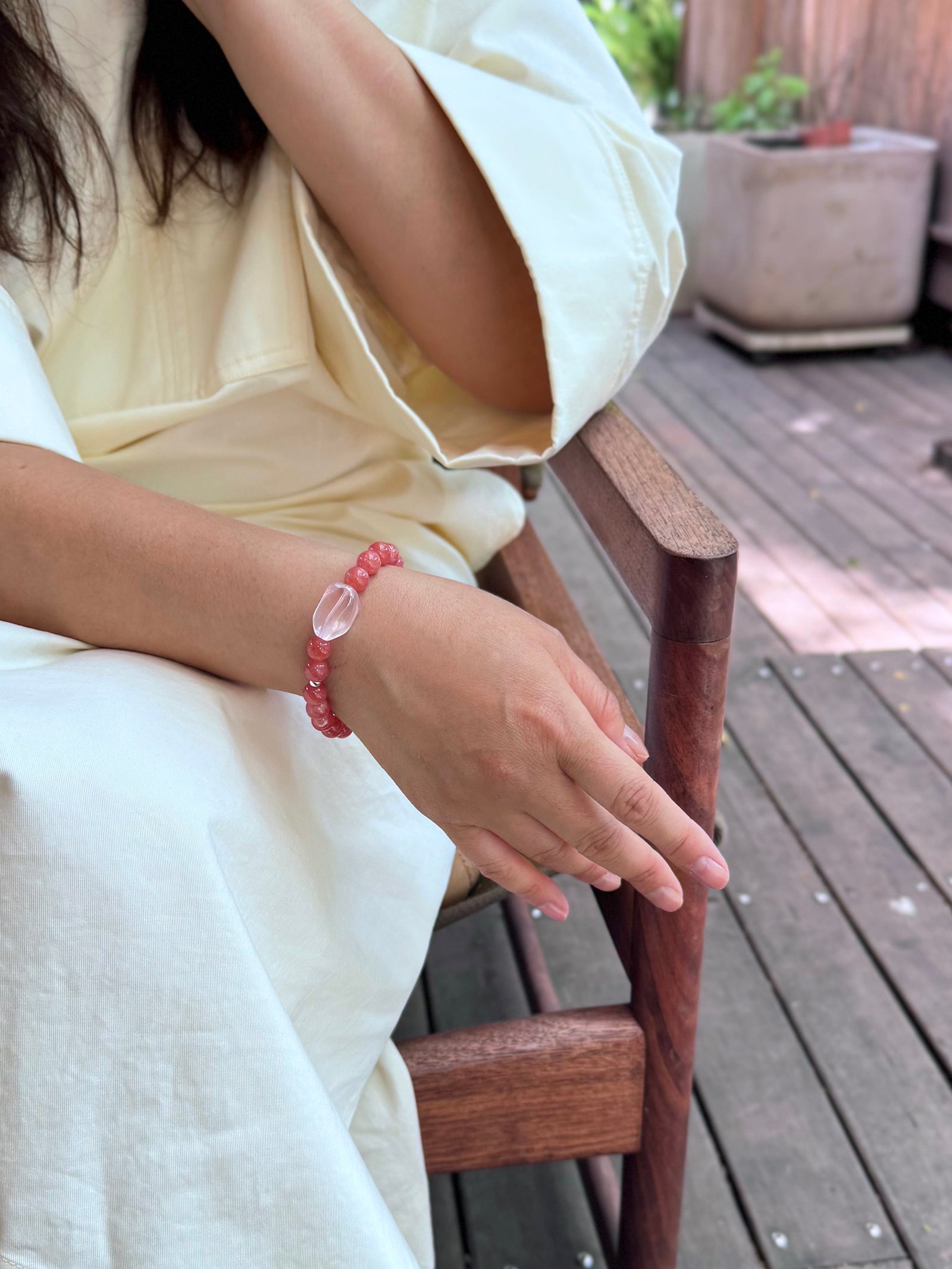Rhodochrosite crystal bracelet worn in a relaxed lifestyle setting for love and emo