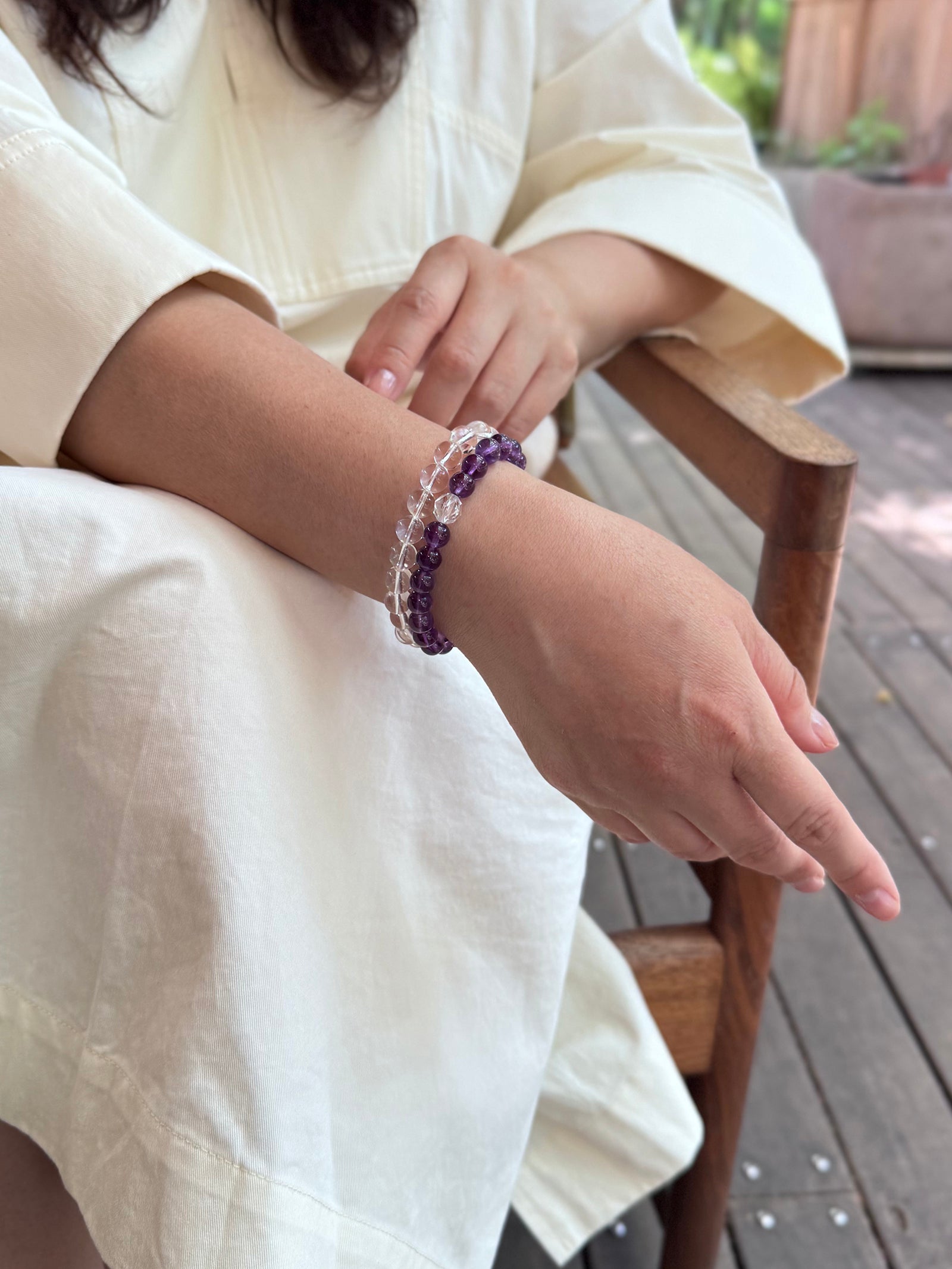 Amethyst bracelet layered with clear quartz bracelet on wrist