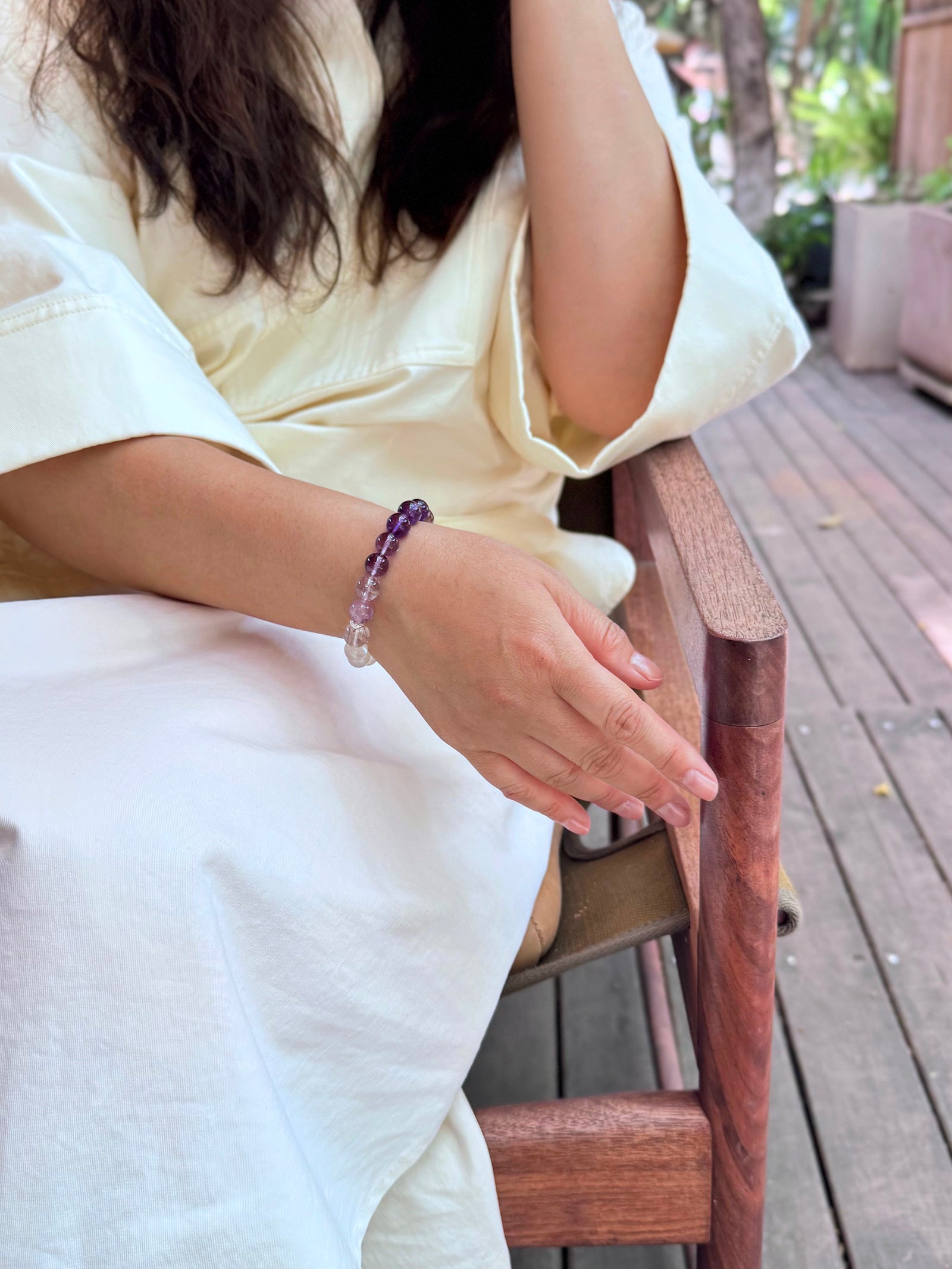 Amethyst, purple titanium quartz, and moonstone bracelet worn in a relaxed lifestyle setting for intuition and inner clarity