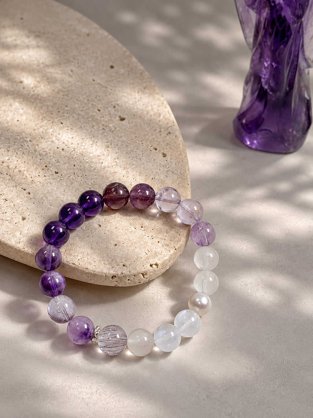 Amethyst, purple titanium quartz, and moonstone bracelet styled on meditation altar for intuition, higher awareness, and inner clarity