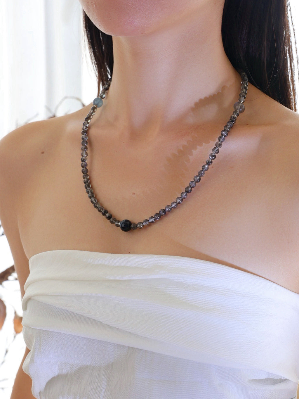 Model wearing a natural Aquamarine with Biotite, Aquamarine, Blue Tiger’s Eye, and Labradorite necklace with 925 sterling silver accents.
