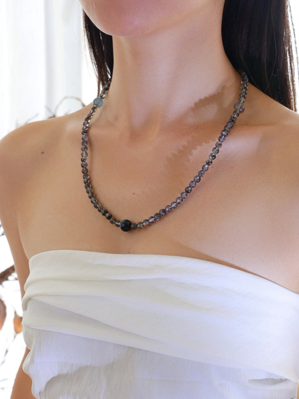 Model wearing a natural Aquamarine with Biotite, Aquamarine, Blue Tiger’s Eye, and Labradorite necklace with 925 sterling silver accents.