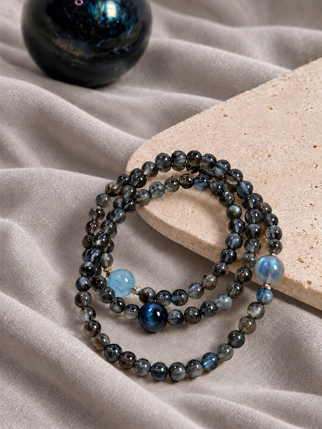 Aquamarine and Biotite crystal bracelet styled with incense and natural stone indoors