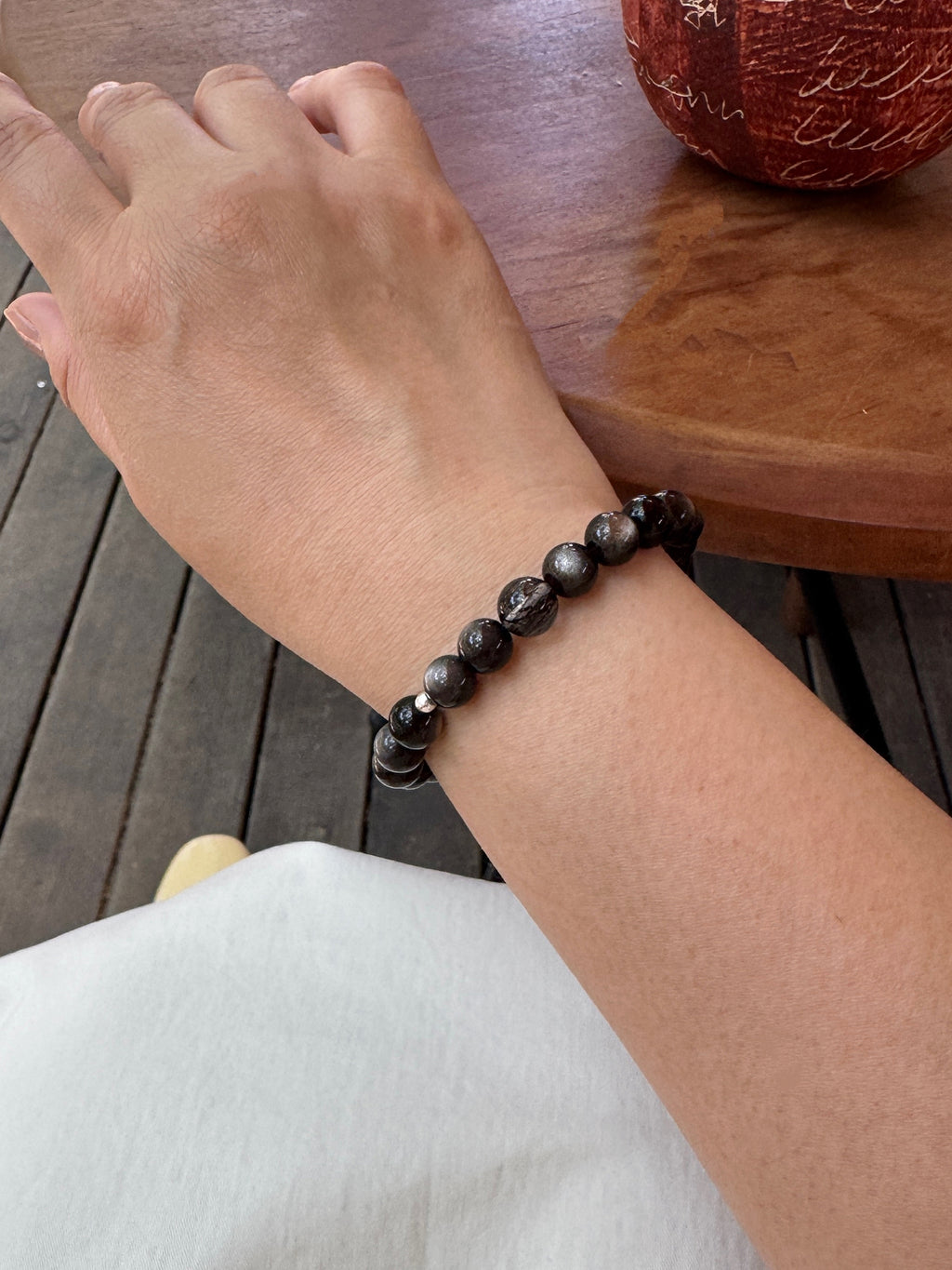 Black obsidian and black rutilated quartz bracelet worn on wrist close-up showing size and fit