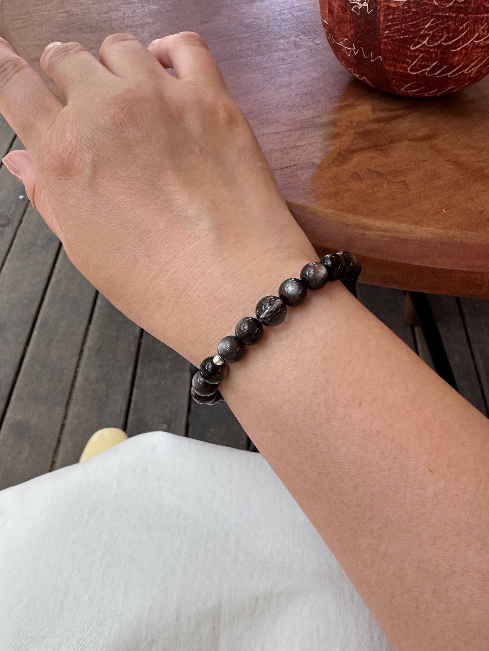 Black obsidian and black rutilated quartz bracelet worn on wrist close-up showing size and fit