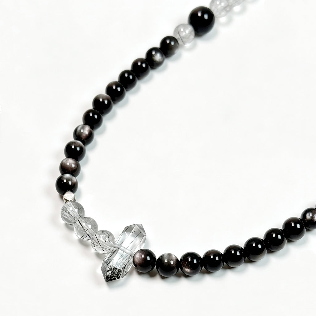 Close-up detail of Black rutilated quartz and obsidian crystal bracelet showing natural texture for stability and energetic boundaries