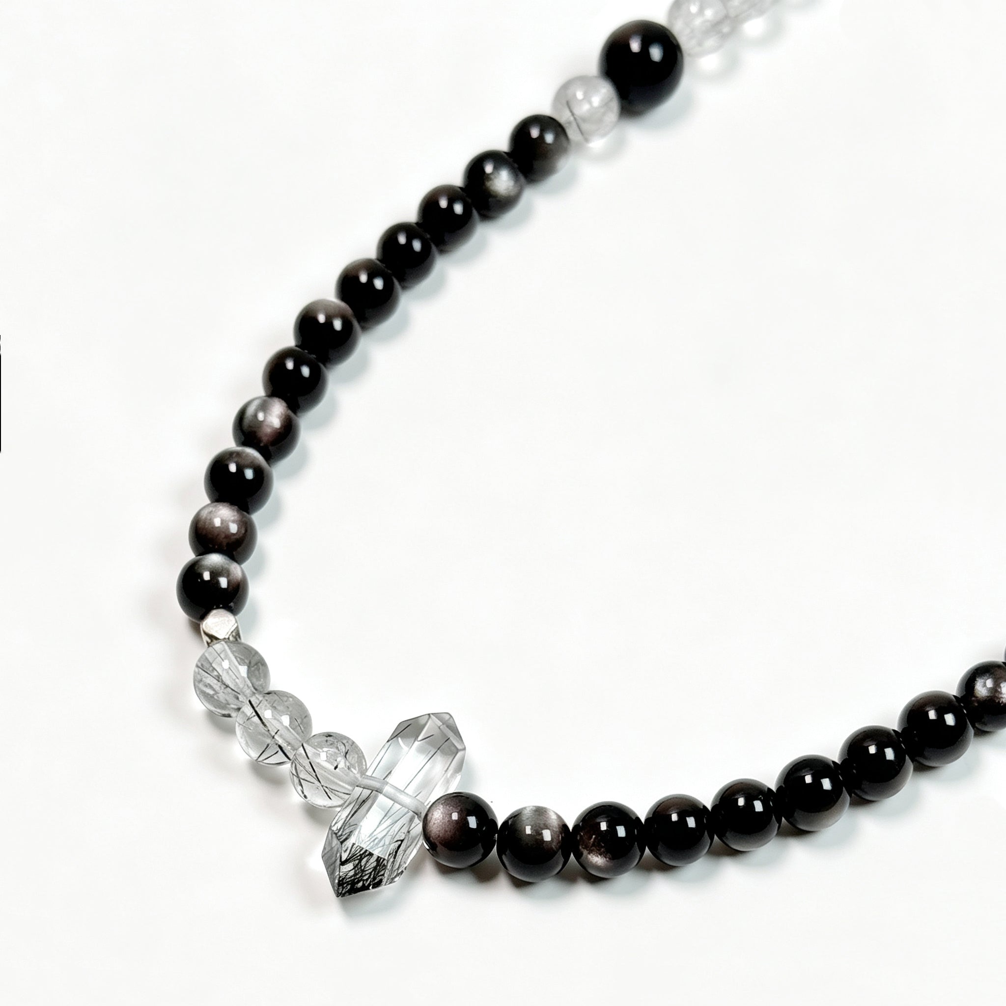 Close-up detail of Black rutilated quartz and obsidian crystal bracelet showing natural texture for stability and energetic boundaries