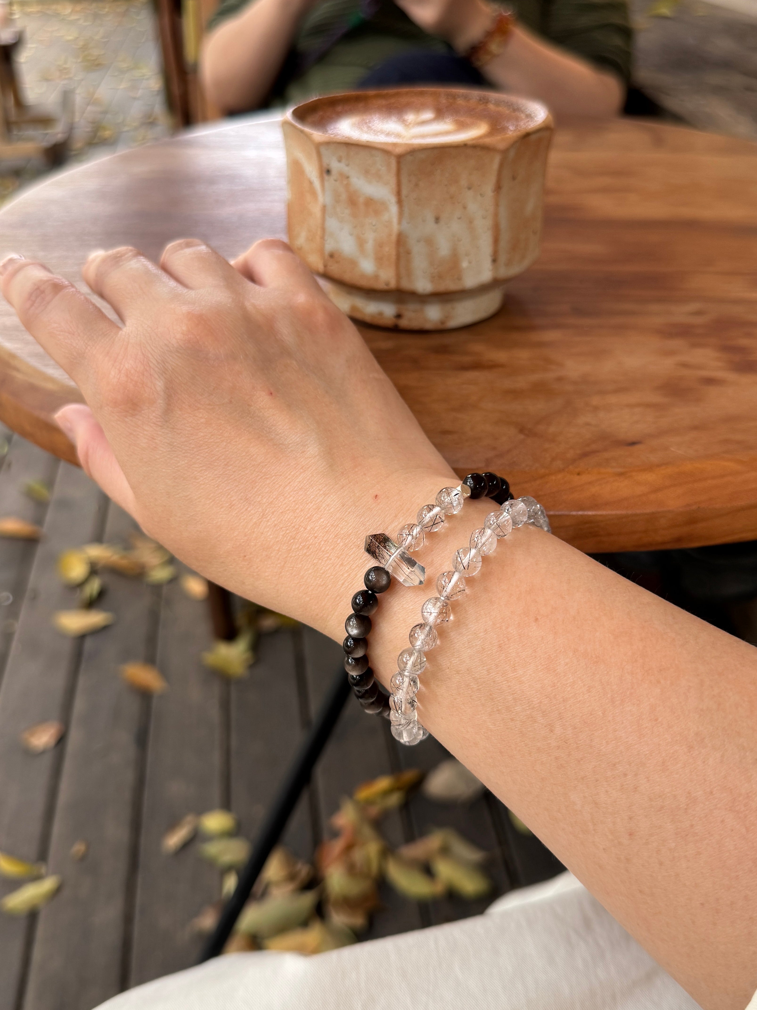 Black rutilated quartz and obsidian crystal bracelet worn on wrist close-up for protection and stability