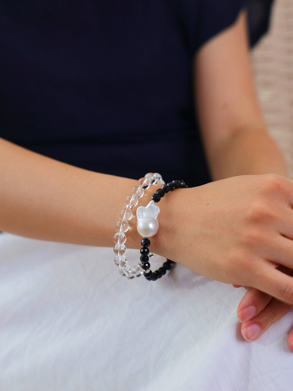 Model wearing a natural Black Spinel and Baroque Freshwater Pearl bracele