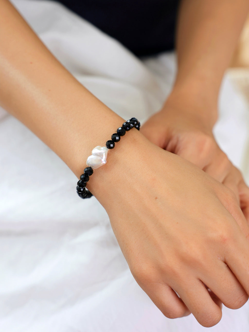 Model wearing a natural Black Spinel and Baroque Freshwater Pearl bracelet