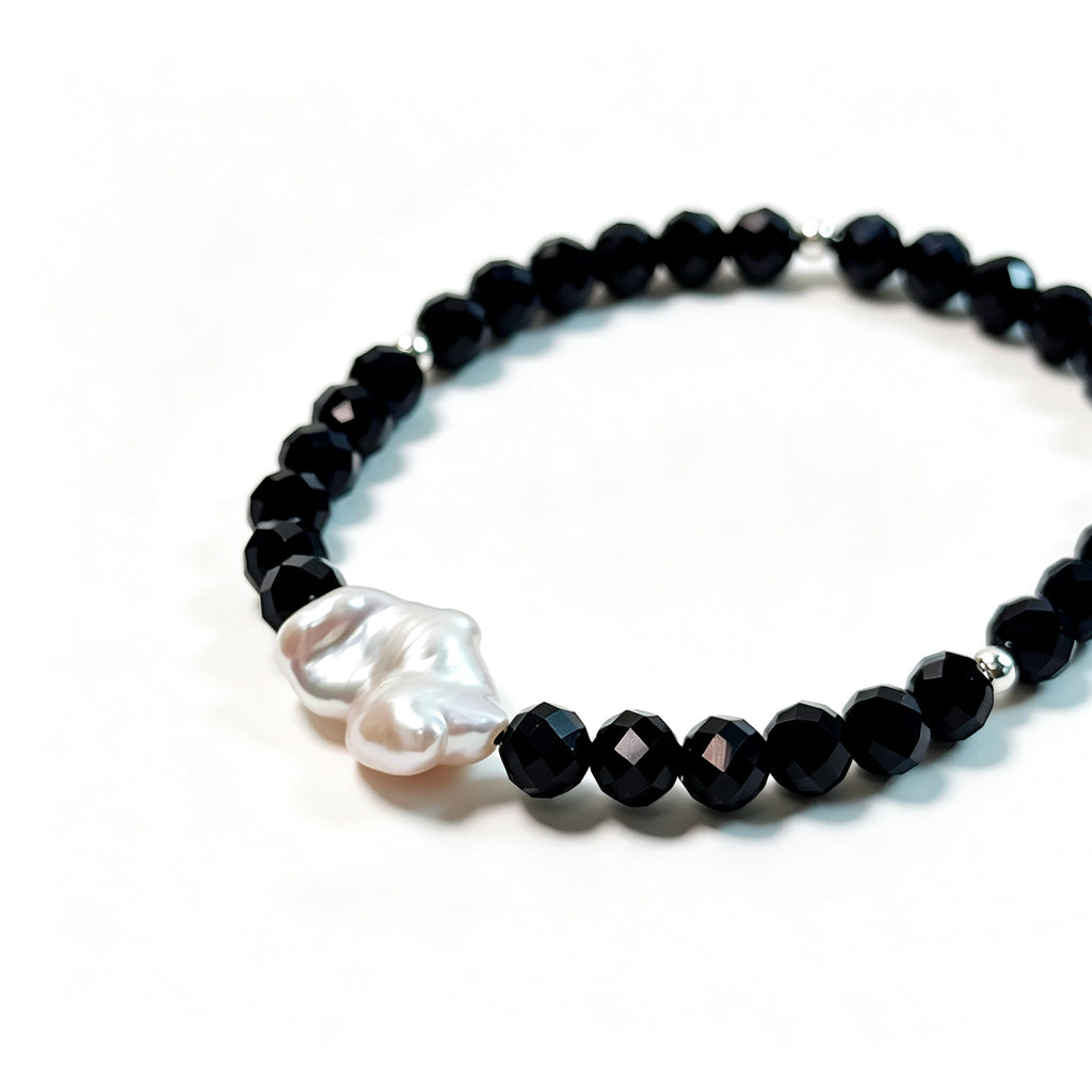Close-up of black spinel, natural baroque pearl and 925 sterling silver bead bracelet