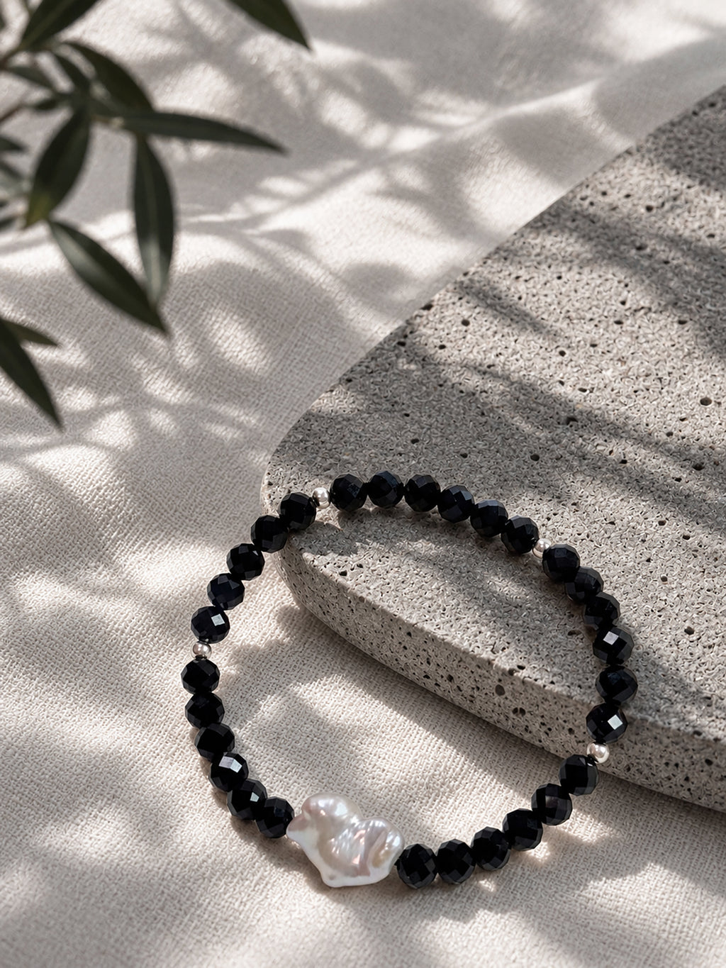 Black spinel and natural baroque pearl bracelet styled in a natural lifestyle setting