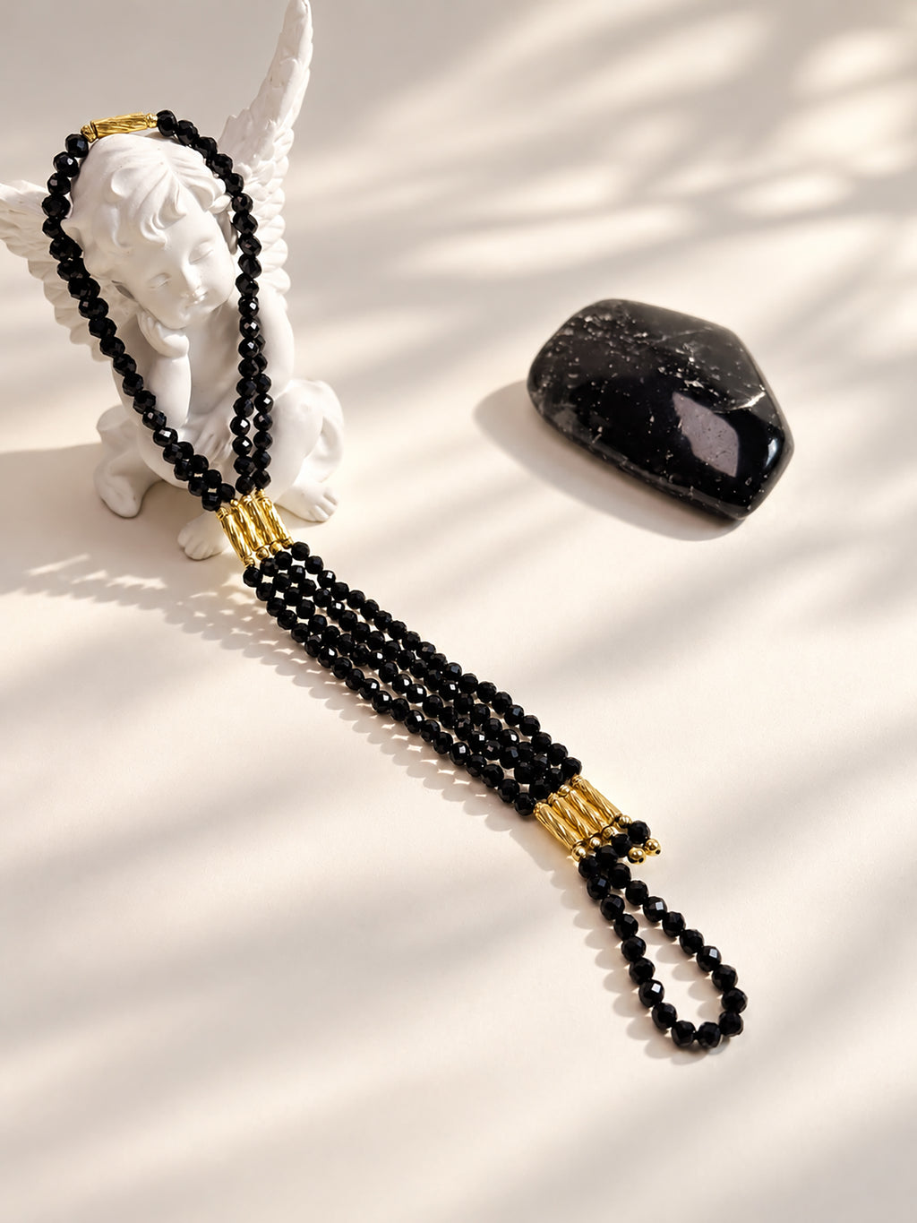 Natural undyed faceted Black Spinel convertible necklace and bracelet in an elegant jewelry lifestyle setting.