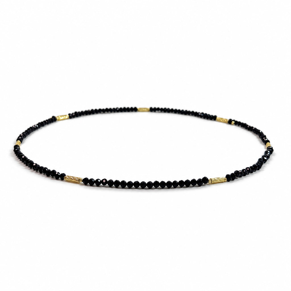 Natural undyed faceted Black Spinel convertible necklace and bracelet, side view on a pure white background.
