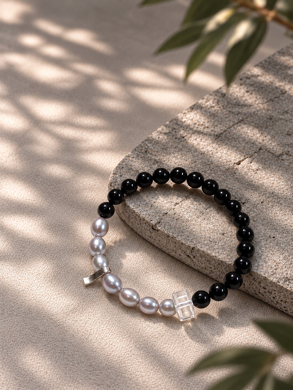 Black tourmaline and gray freshwater pearl bracelet in a natural lifestyle setting