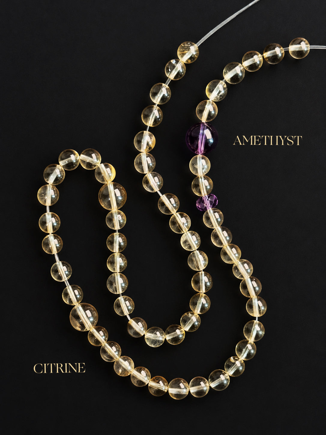 High-clarity citrine and amethyst double-wrap bracelet on a dark charcoal background, showcasing translucent pale yellow citrine beads, purple amethyst accents, and natural mineral inclusions.