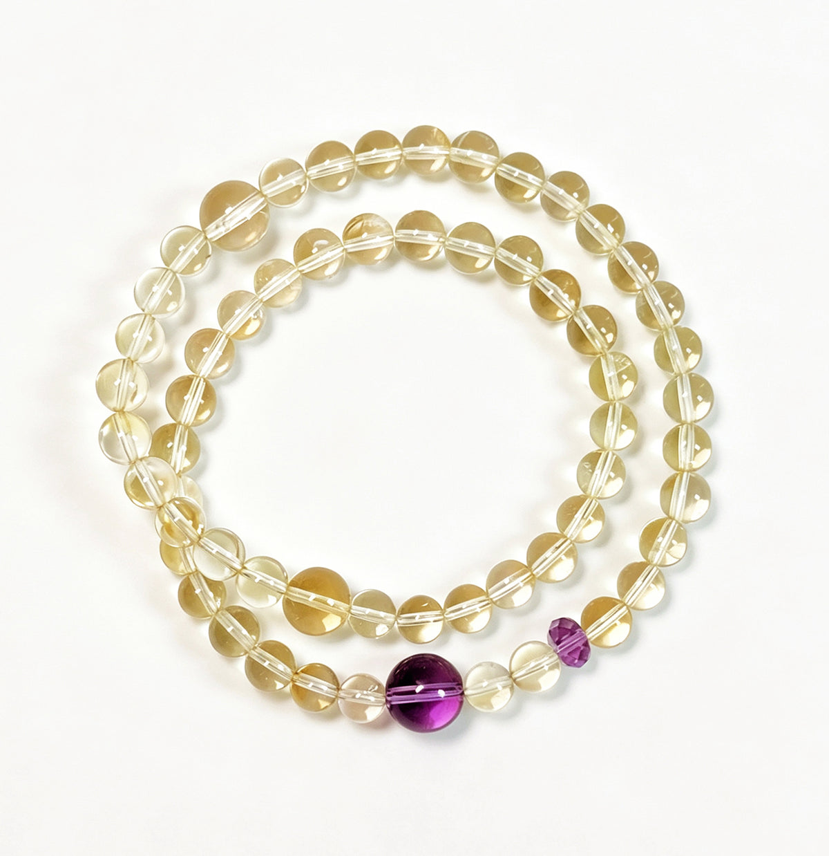 Top view of a natural citrine and amethyst double-wrap bracelet showcasing pale yellow crystal beads, purple amethyst accents, and delicate gemstone details.