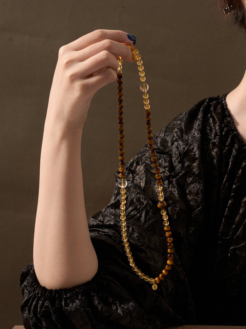 Woman holding Citrine and Tiger’s Eye triple wrap bracelet showing full layered design and natural golden crystal tones