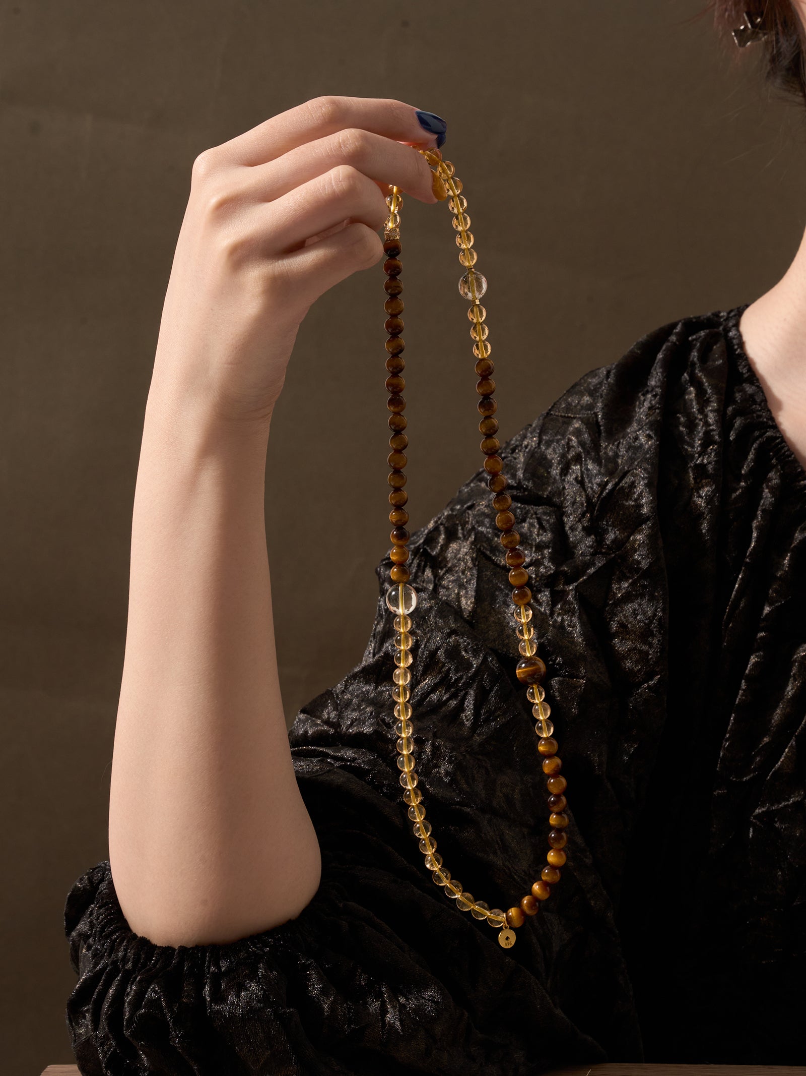 Woman holding Citrine and Tiger’s Eye triple wrap bracelet showing full layered design and natural golden crystal tones