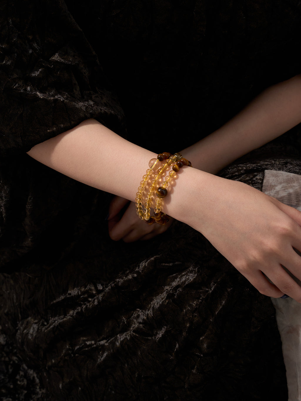Close-up of Citrine and Tiger’s Eye triple wrap bracelet worn on wrist showing layered fit and crystal details