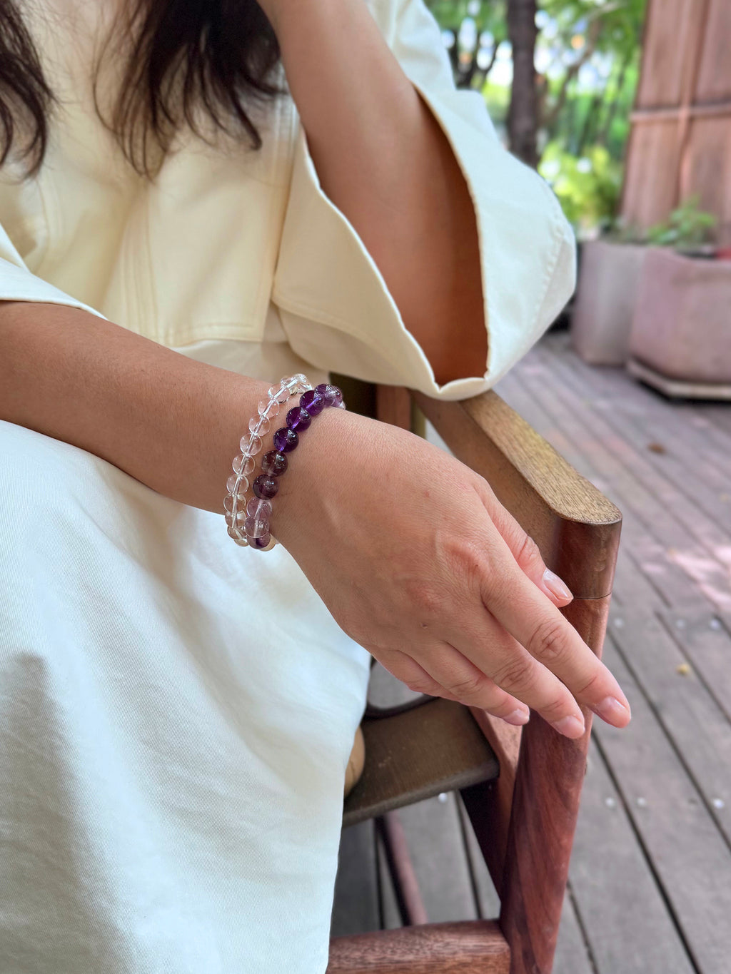 Clear quartz bracelet layered with amethyst bracelet close-up on wrist