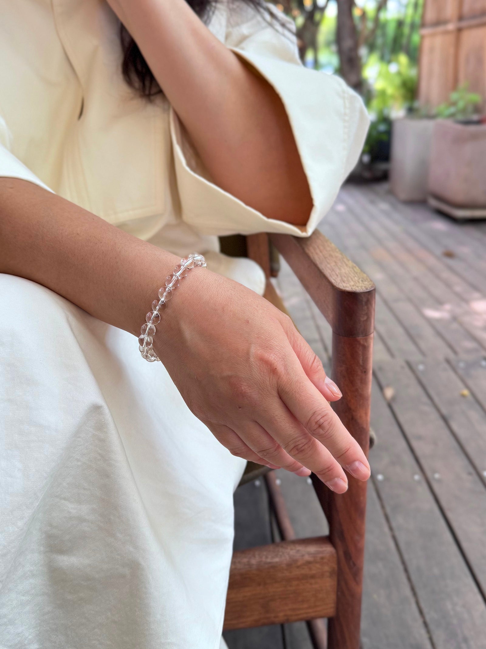 Clear quartz crystal bracelet worn in a relaxed lifestyle setting for healing and balance