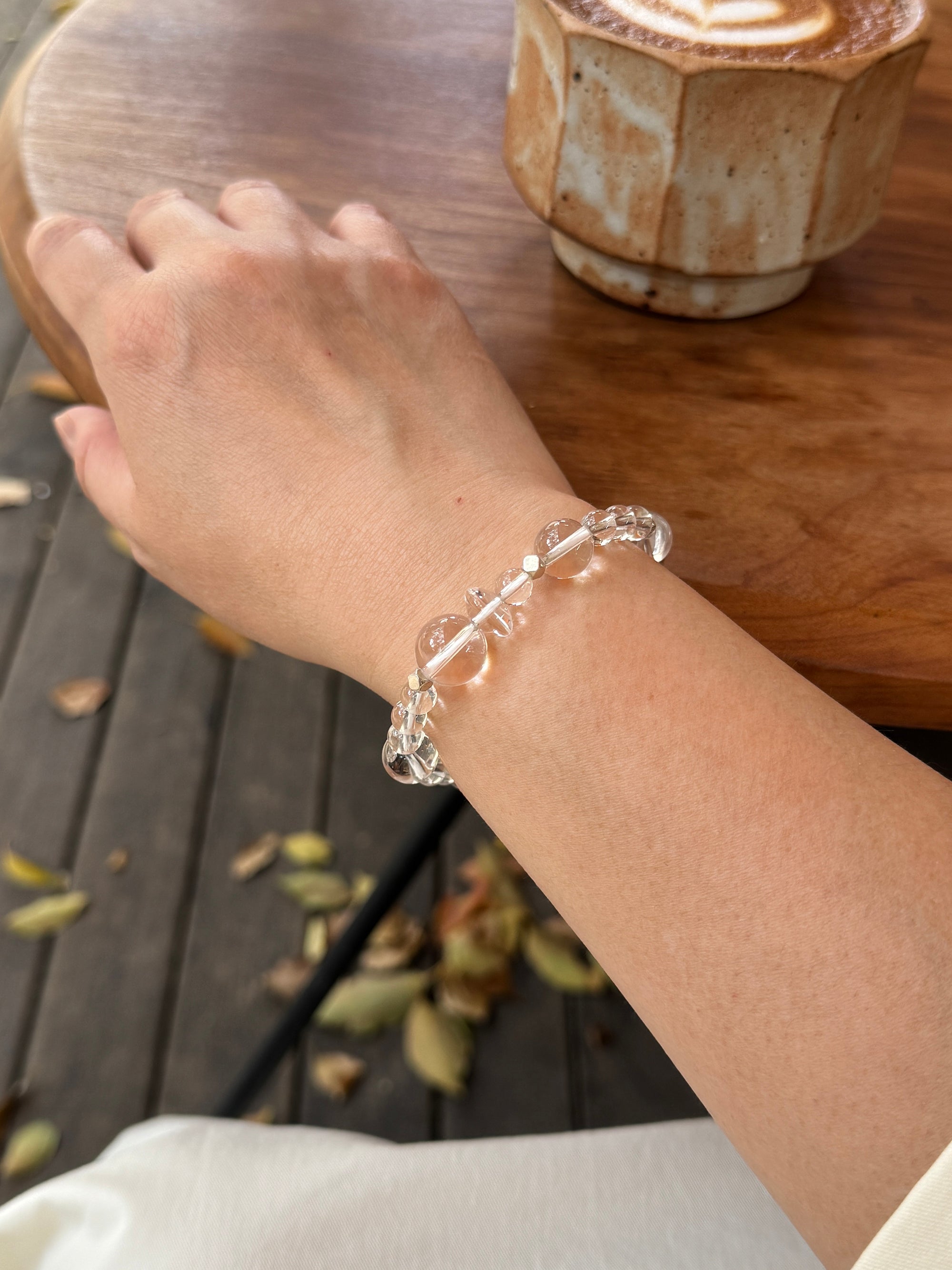 Clear quartz crystal bracelet worn on wrist close-up showing size and fit