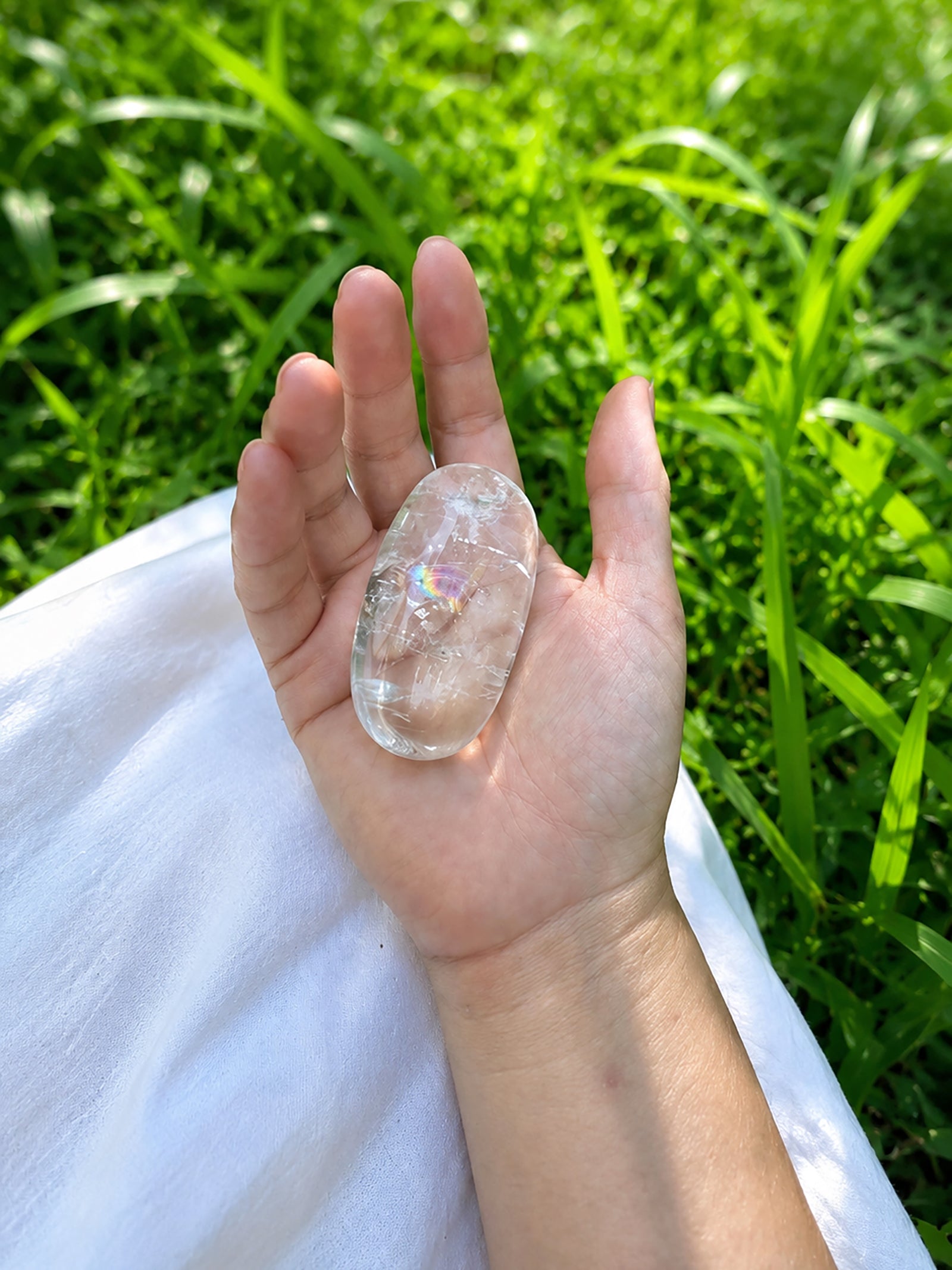 
Natural clear quartz rainbow crystal shown in palm for size reference.
