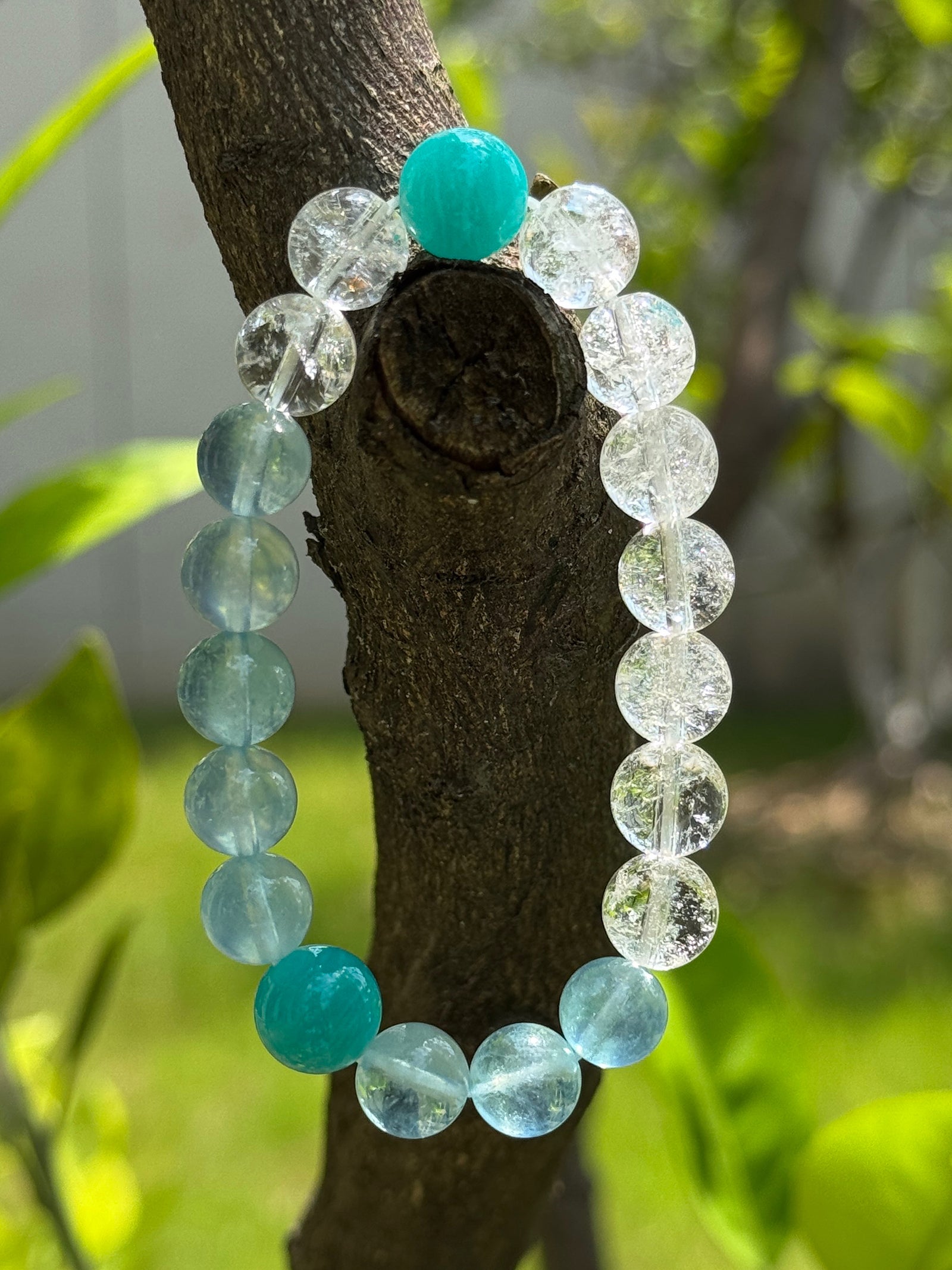 Clear Quartz crystal bracelet showing natural rainbow reflections and organic ice-like crystal textures