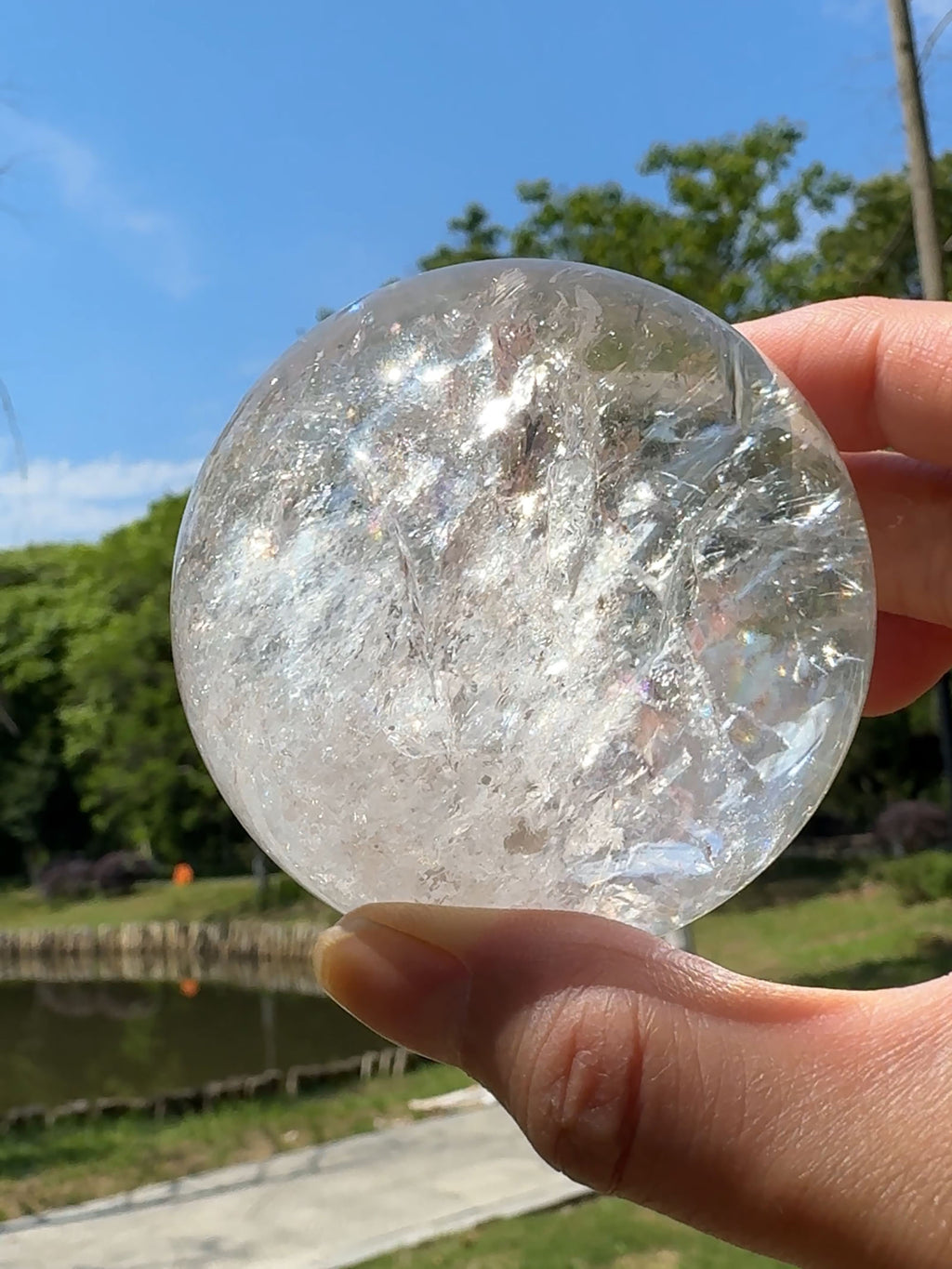 Natural rainbow reflections inside a clear quartz sphere in sunlight.
