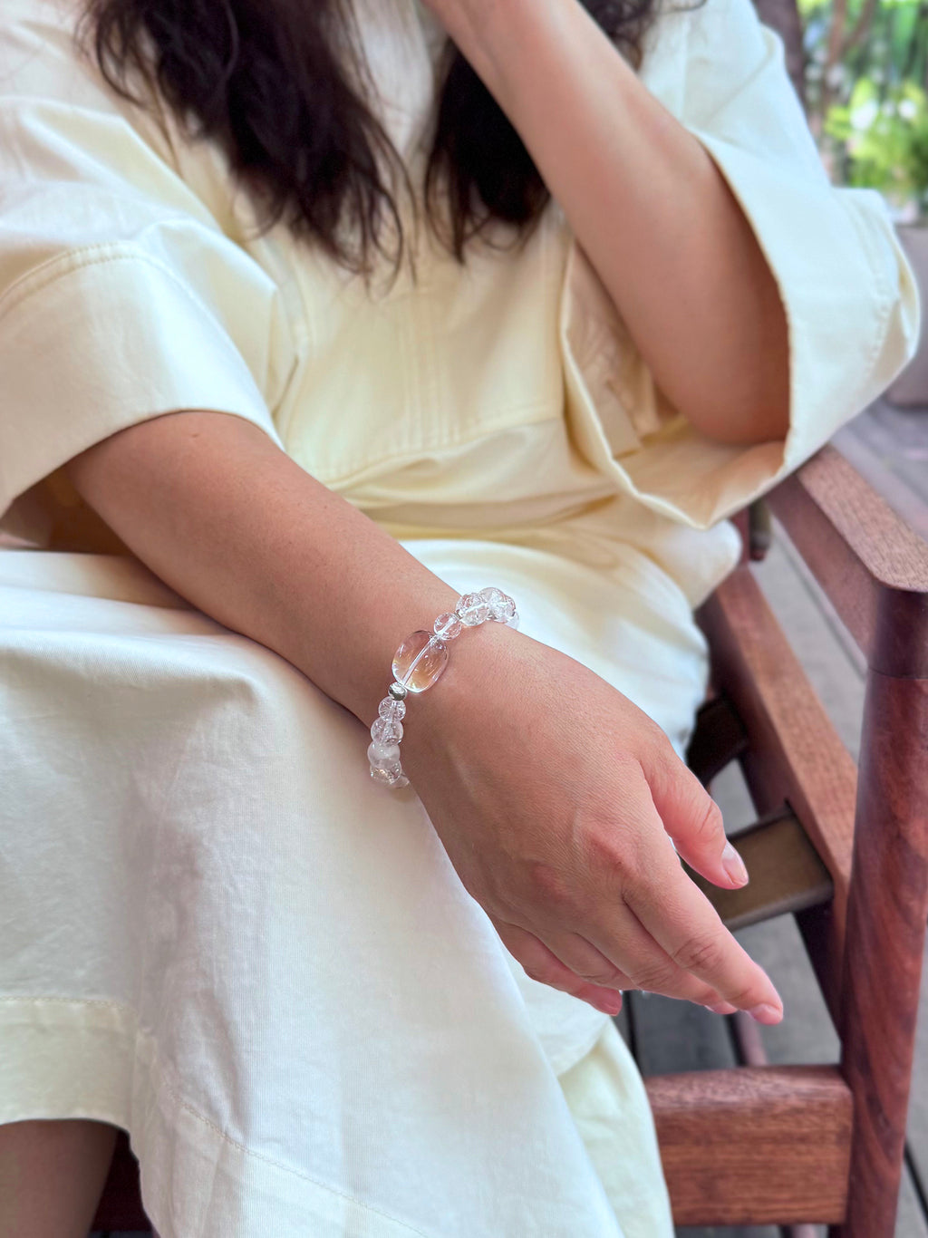 Clear Quartz and White Phantom Quartz bracelet worn in relaxed lifestyle setting showing soft luminous crystal tones
