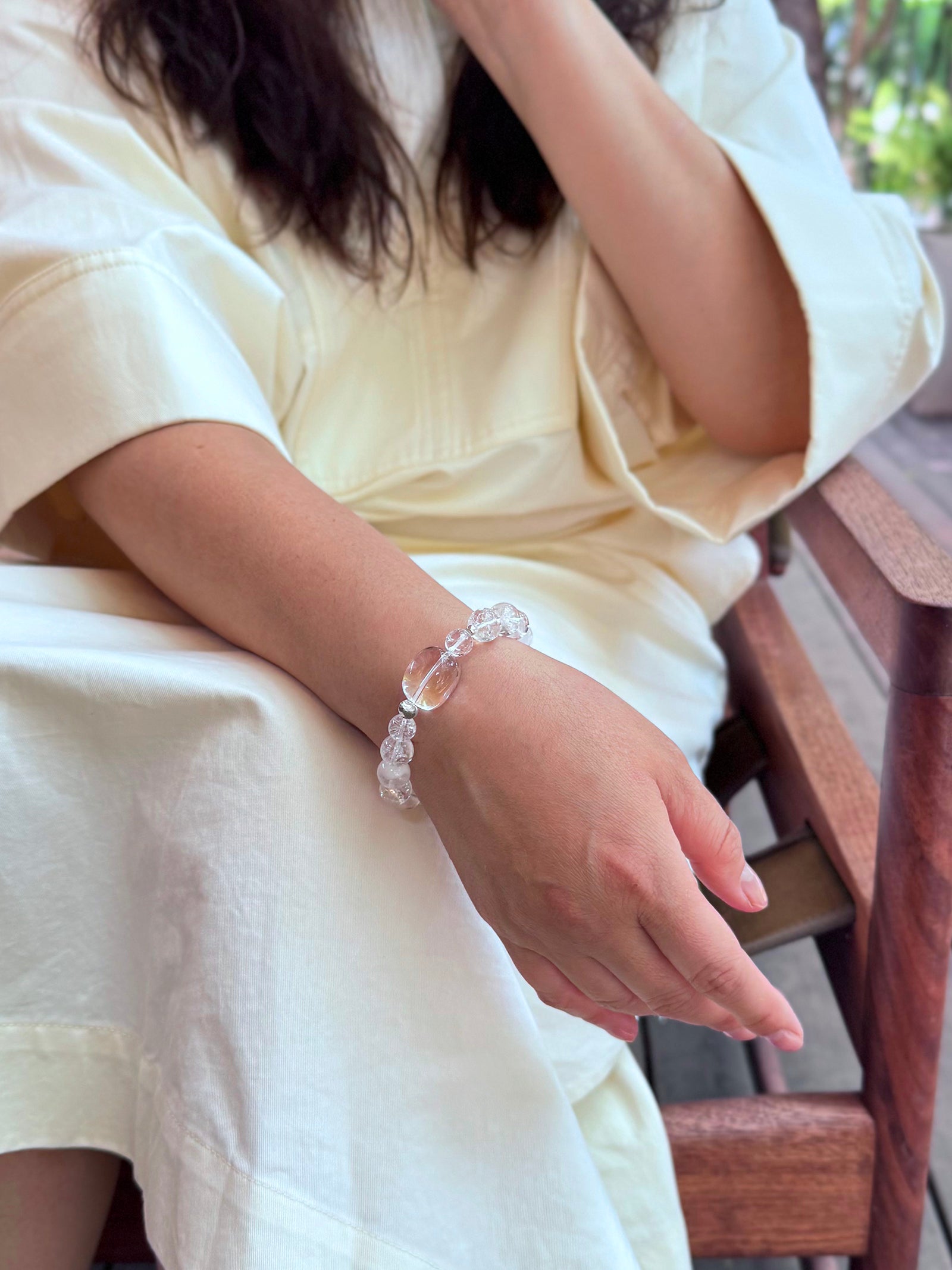Clear Quartz and White Phantom Quartz bracelet worn in relaxed lifestyle setting showing soft luminous crystal tones
