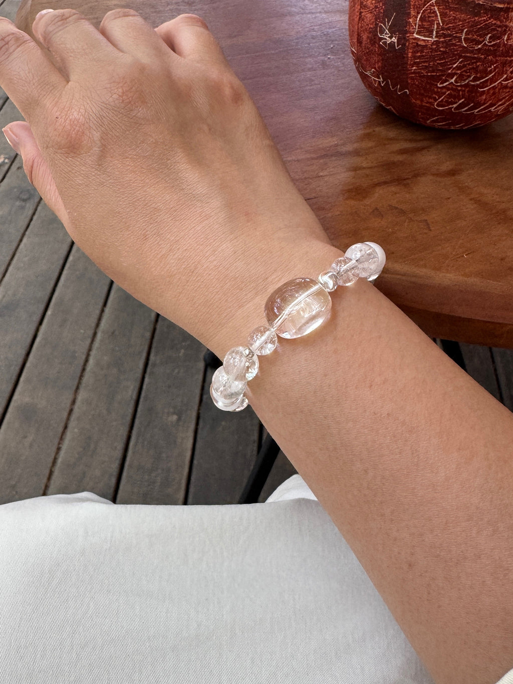Close-up of Clear Quartz and White Phantom Quartz bracelet worn on wrist showing crystal clarity and fit