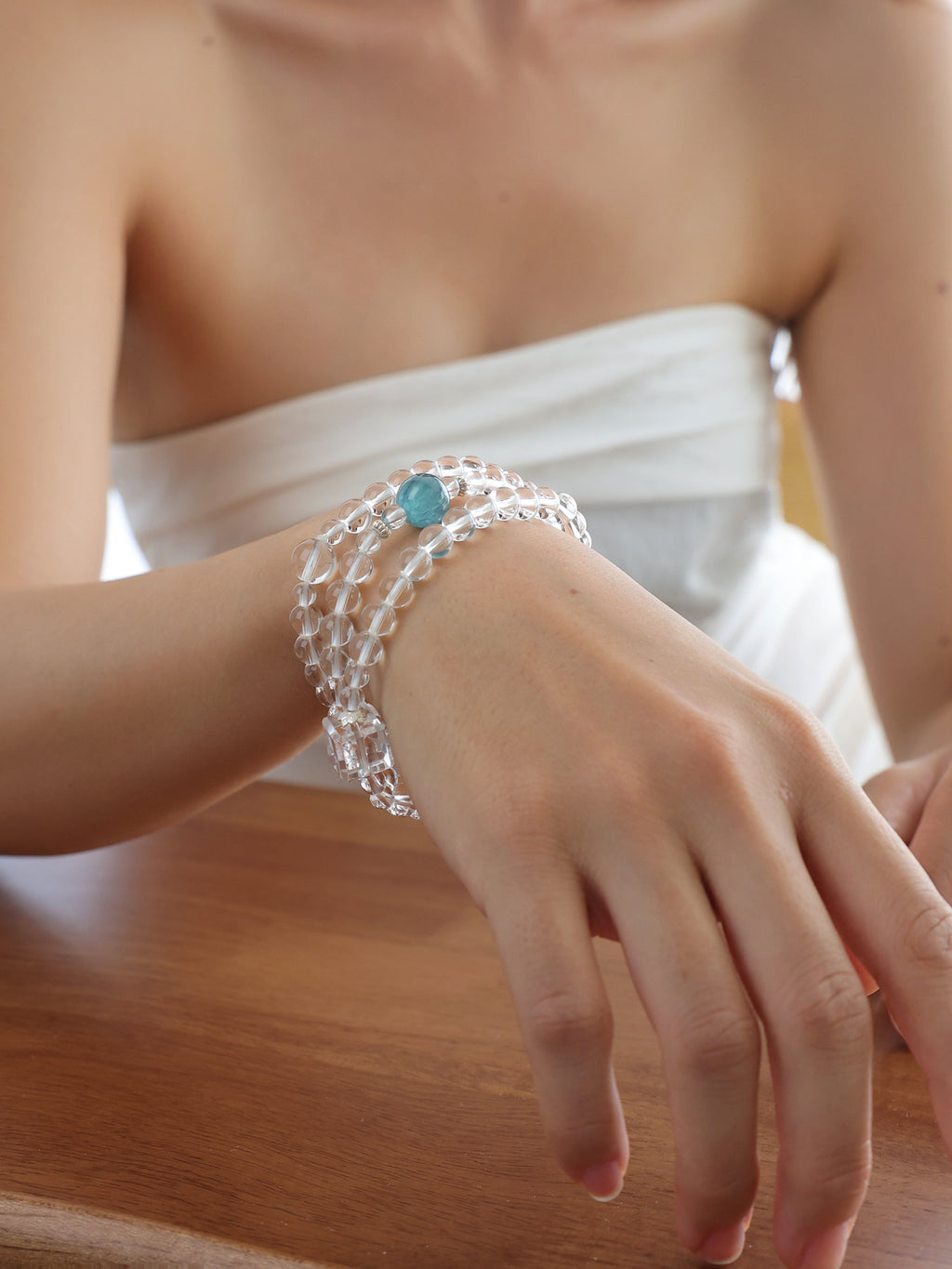 Model wearing a collector-grade Clear Quartz and Monet Blue-Green Kyanite triple-wrap bracelet with 925 sterling silver.