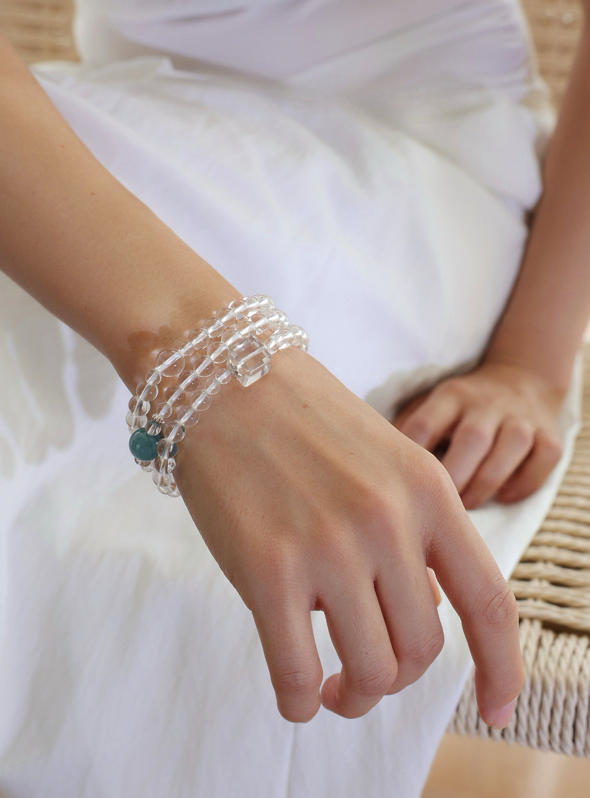 Model wearing a collector-grade Clear Quartz and Monet Blue-Green Kyanite triple-wrap bracelet with 925 sterling silver.