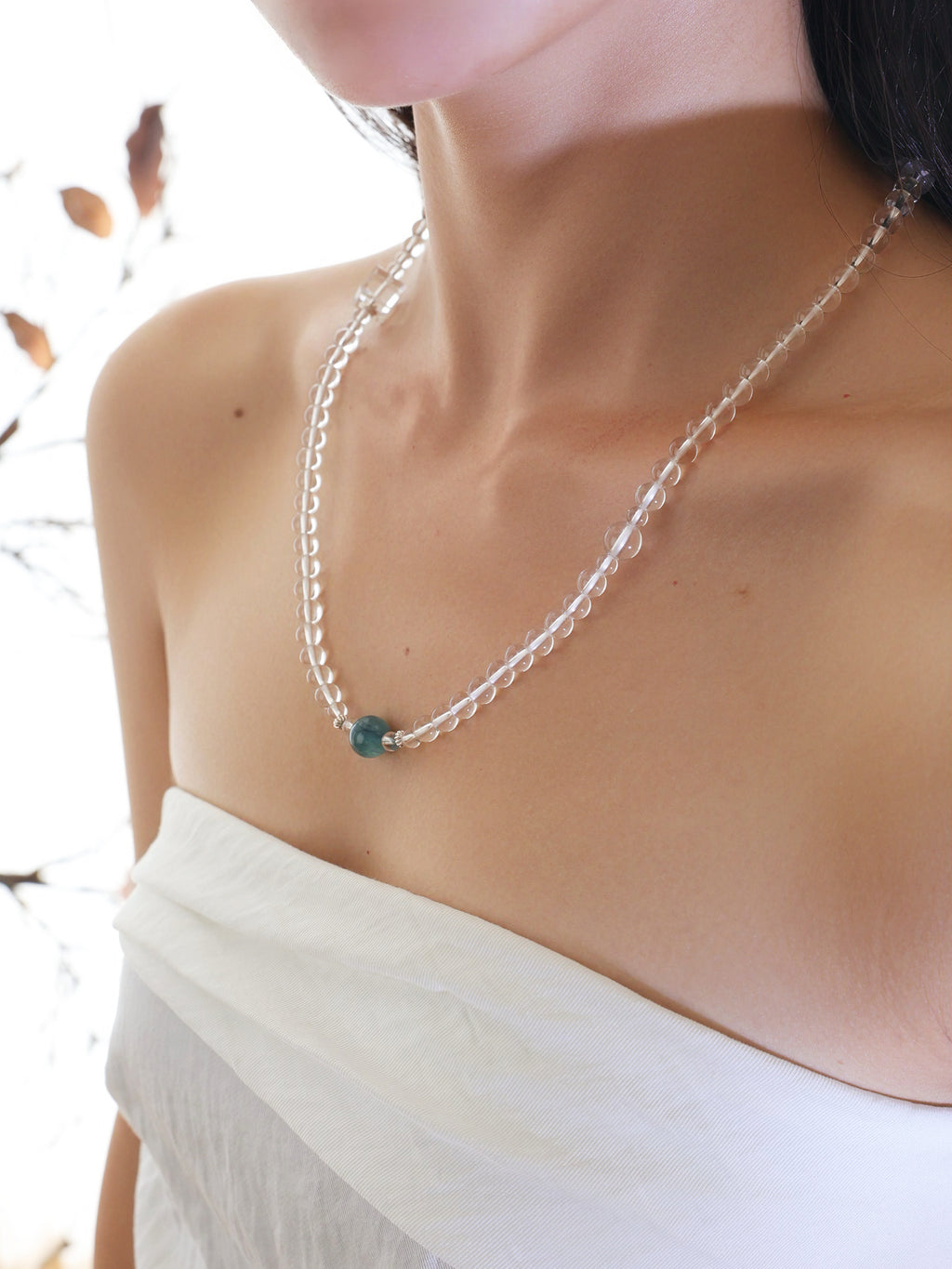 Model wearing a collector-grade Clear Quartz and Monet Blue-Green Kyanite single-strand necklace with 925 sterling silver.
