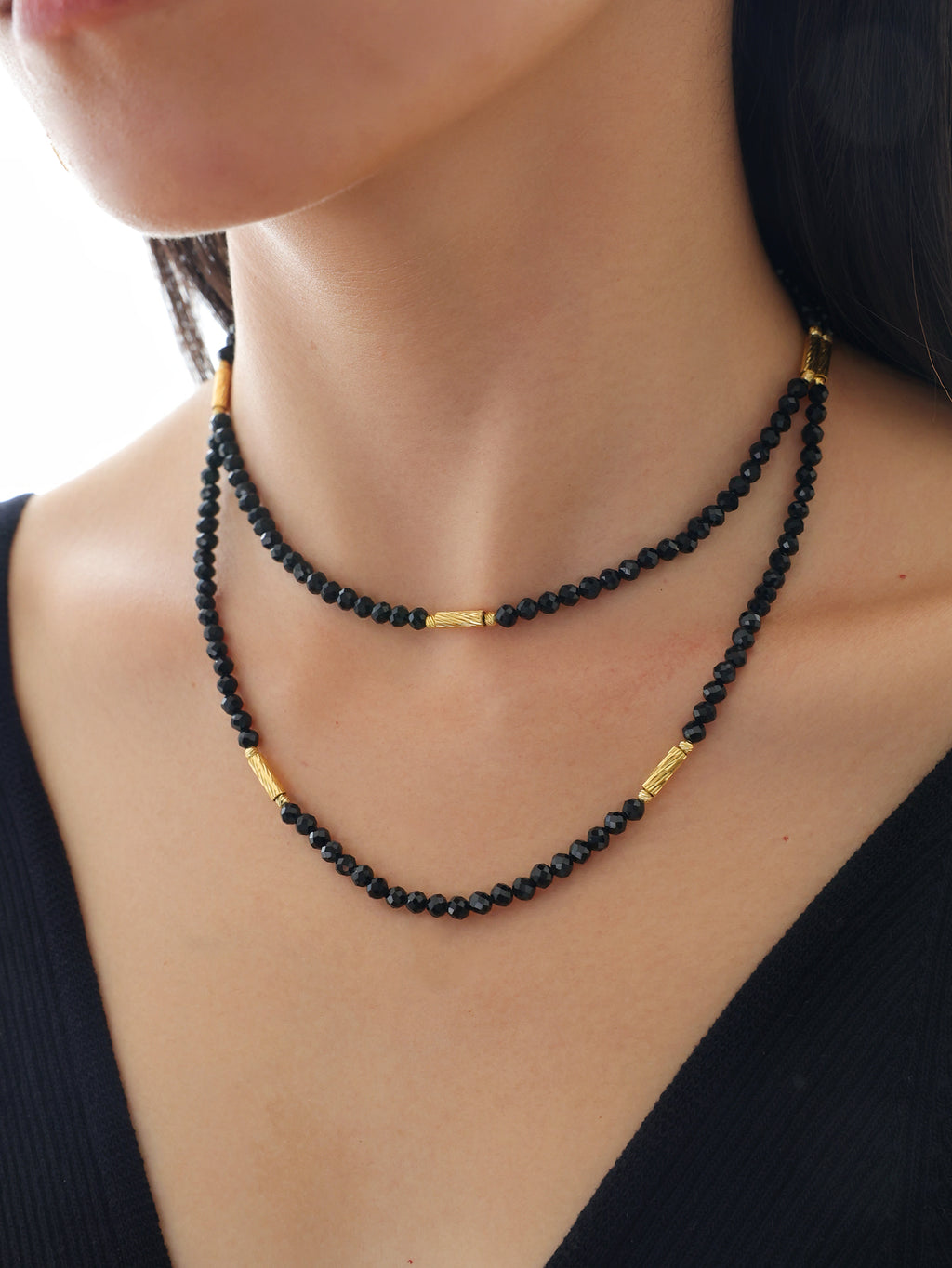 Model wearing a natural undyed faceted Black Spinel convertible necklace styled for an elegant evening party look.