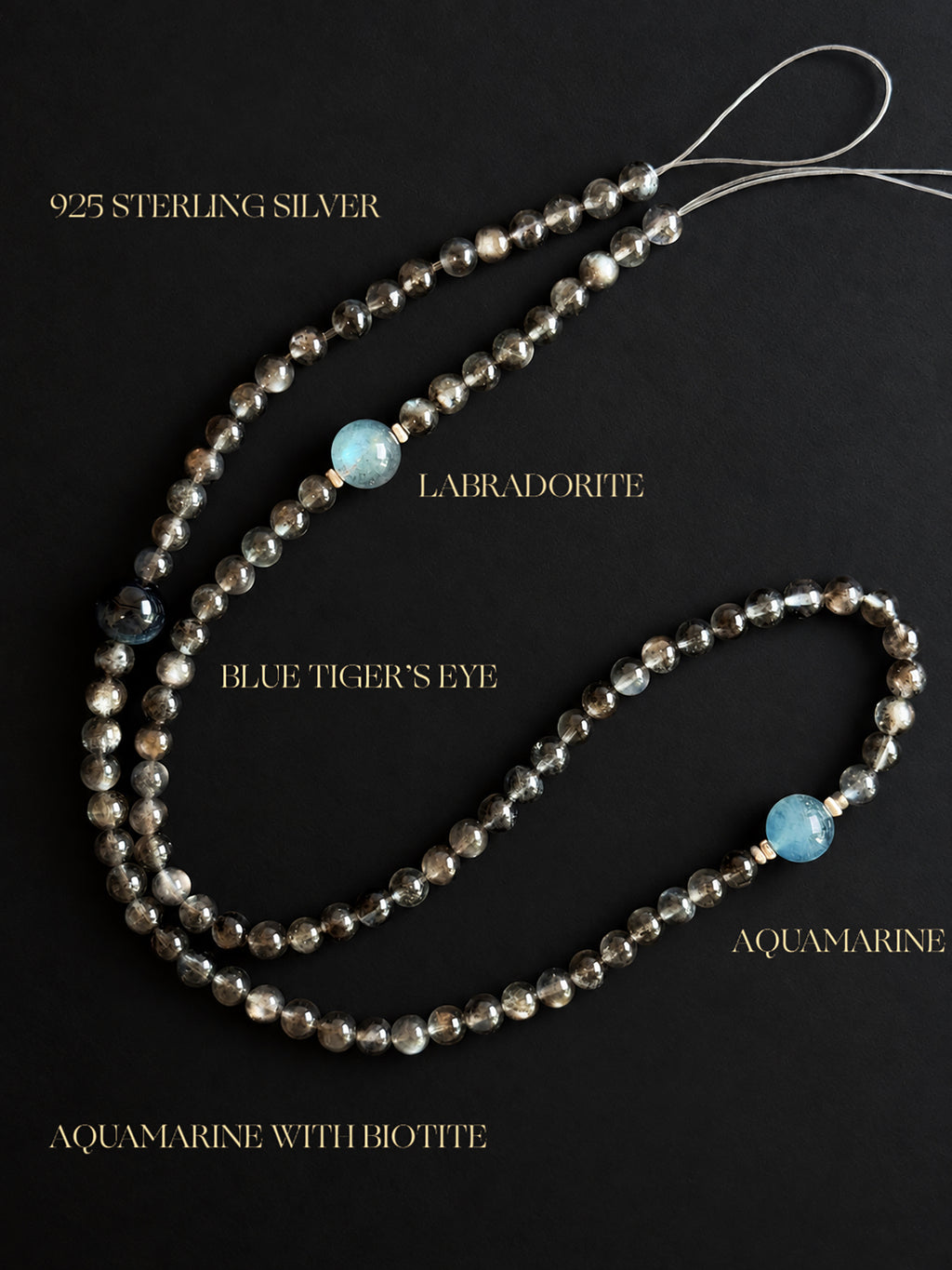 Fine Aquamarine with Biotite, Aquamarine, Blue Tiger’s Eye, and Labradorite convertible bracelet and necklace with 925 sterling silver accents, displayed against a black mineral backgroun