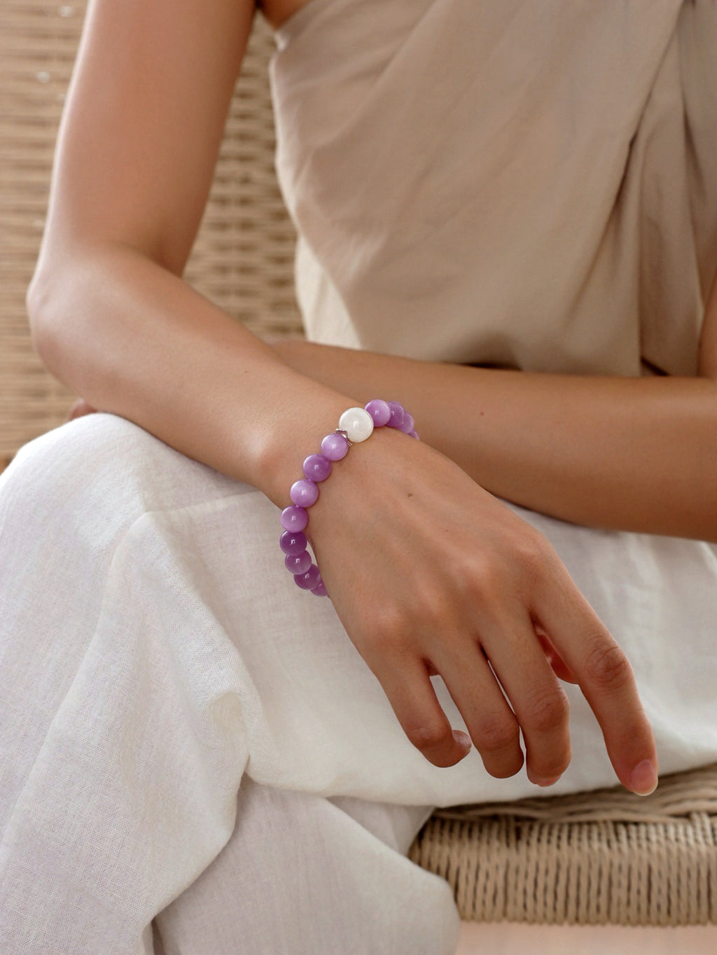 Model wearing a natural Fine Cat’s Eye Kunzite, Charoite and White Phantom Quartz bracelet