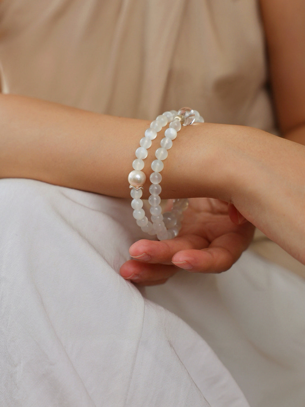 Model wearing a natural White Moonstone, Clear Quartz and Freshwater Pearl double wrap bracelet