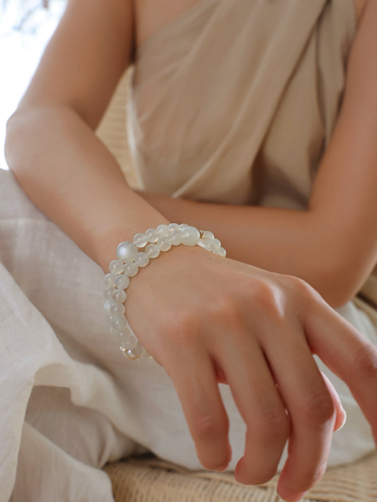 Model wearing a natural White Moonstone, Clear Quartz and Freshwater Pearl double wrap bracelet