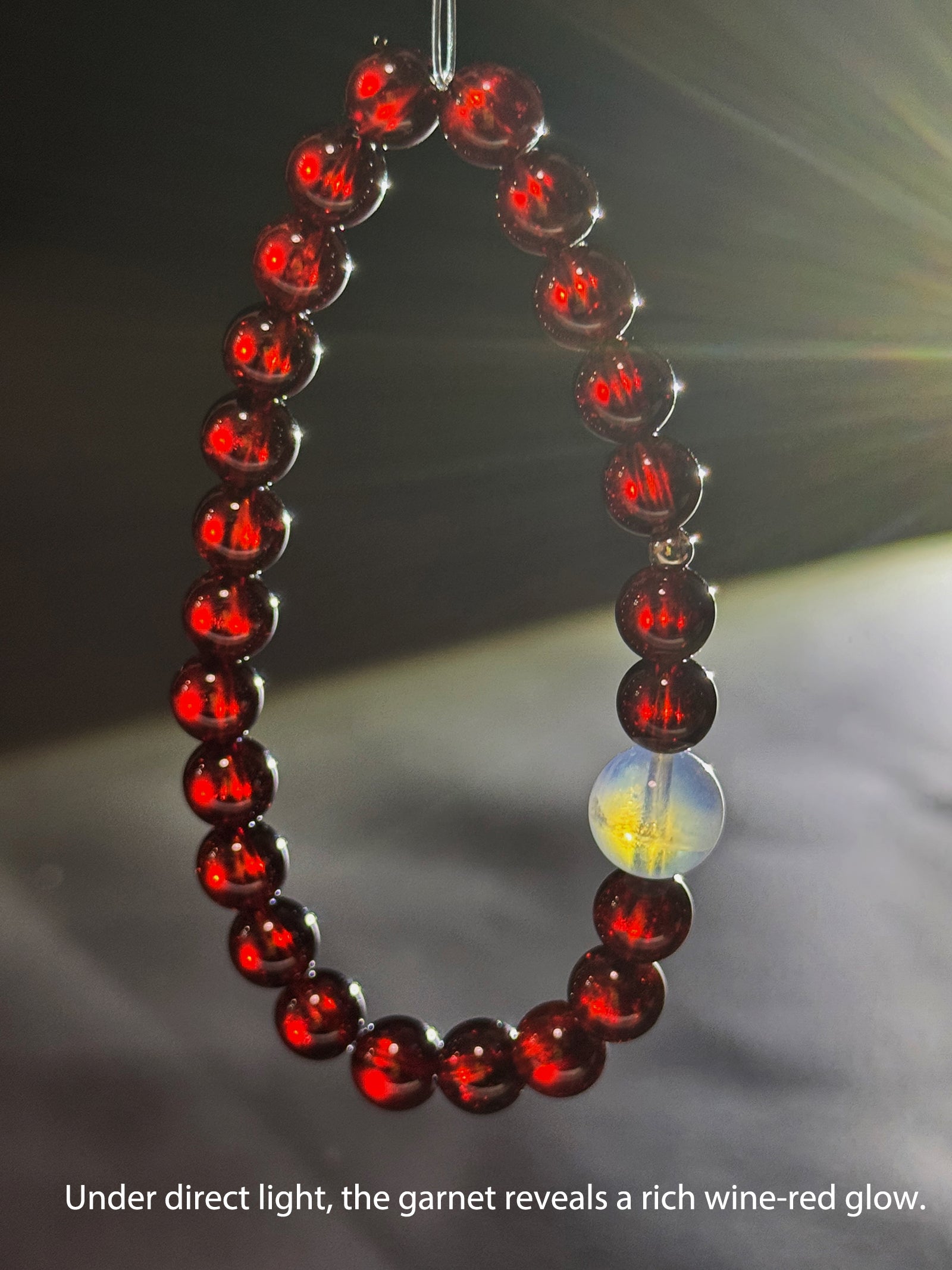 Natural garnet bracelet revealing rich wine-red glow under direct light