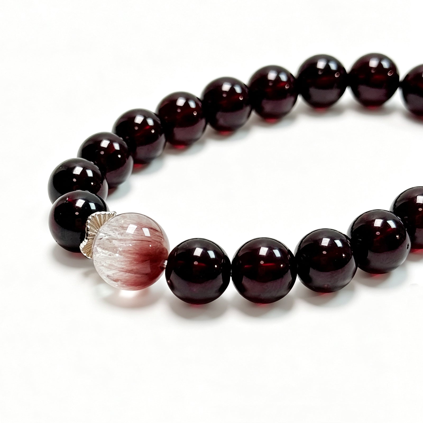 Close-up detail of garnet and pink rabbit hair quartz bracelet showing natural crystal texture