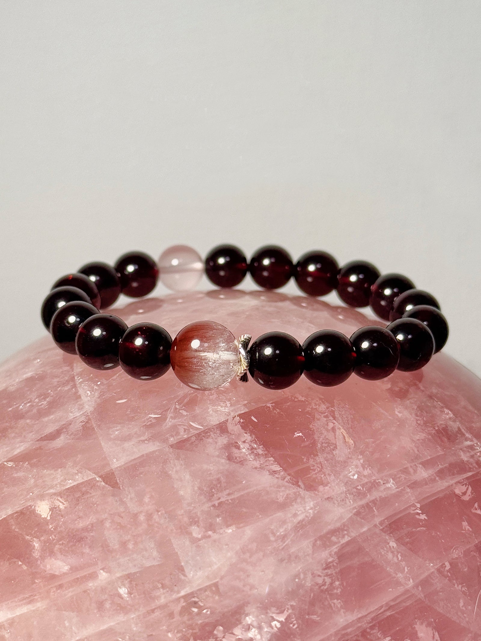 
Garnet rose quartz and pink rabbit hair quartz bracelet in artistic still life composition